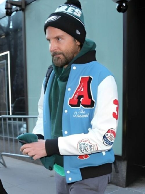 Bradley Cooper in a basketball jacket and hat, showcasing a stylish NYC basketball varsity look.