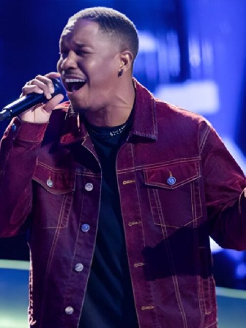 Antonio Ramsey in a red denim jacket passionately sings into a microphone on The Voice Season 27 stage.