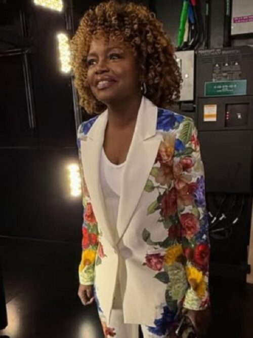 A stylish The View 2025 Karine Pierre White Floral Blazer, featuring a chic white base with vibrant floral prints on the sleeves, worn elegantly on set.
