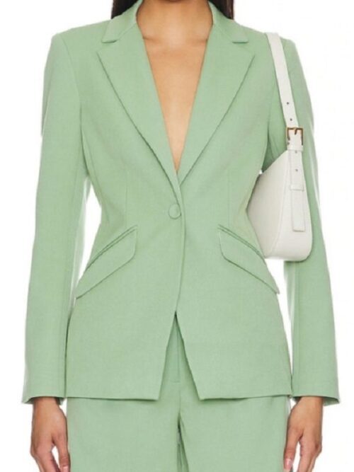 Aja Naomi King, dressed in a mint green blazer, embodying her role in Grosse Pointe Garden Society.