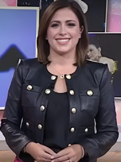 Chloe Melas wearing a black jacket and a pink skirt stands confidently in the The Today Show, showcasing a stylish and modern outfit.