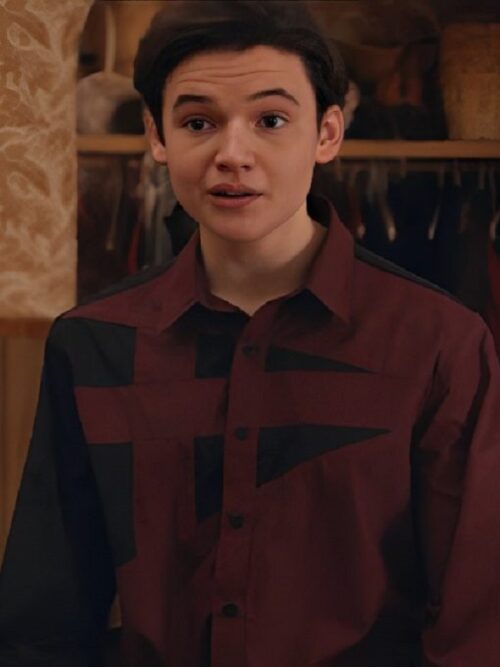 Son Of A Critch S4 Benjamin Evan Ainsworth Burgundy Shirt – A young man wears a stylish maroon and black geometric-patterned button-up shirt, standing in front of an open closet.
